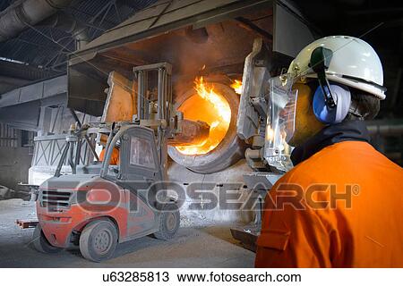 Worker watching furnace at aluminum recycling plant View Large Photo Image Stock Image - Worker watching furnace at aluminum recycling plant. Fotosearch