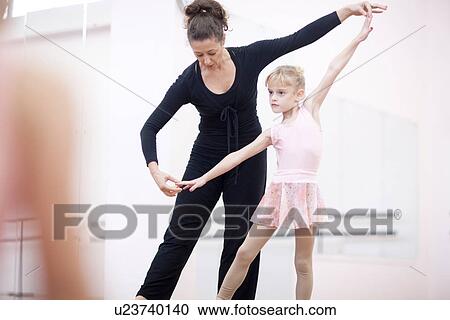 Young ballerina practicing pose with teacher View Large Photo Image Stock Image - Young ballerina practicing pose with teacher. Fotosearch