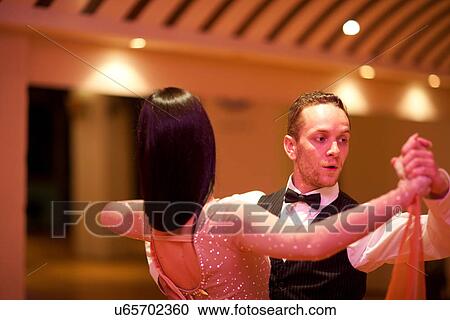 Stock Image - Young ballroom dancers in studio. Fotosearch