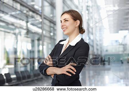 Young businesswoman standing in lobby, smiling View Large Photo Image Stock Photo - Young businesswoman standing in lobby, smiling. Fotosearch