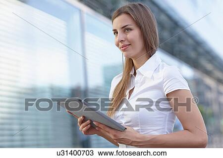Young businesswoman using digital tablet, smiling View Large Photo Image Stock Image - Young businesswoman using digital tablet, smiling. Fotosearch
