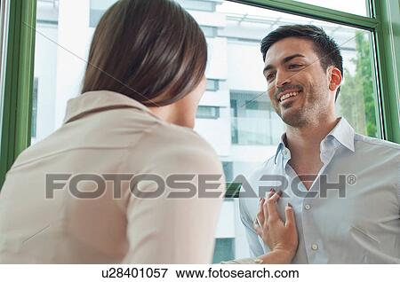 Stock Photo - Young colleagues flirting in office. Fotosearch