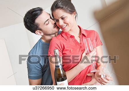 Stock Image - Young couple celebrating with champagne. Fotosearch