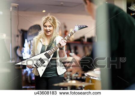 Stock Image - Young couple in music store. Fotosearch