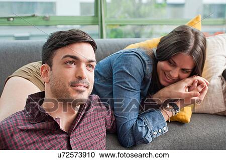 Young couple lounging on sofa View Large Photo Image Stock Image - Young couple lounging on sofa. Fotosearch