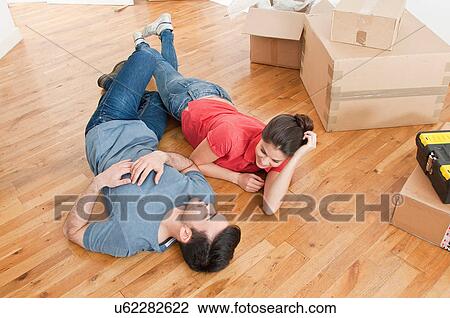 Young couple lying on floor amongst cardboard boxes View Large Photo Image Stock Image - Young couple lying on floor amongst cardboard boxes. Fotosearch