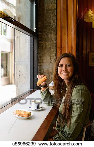 Young female eating sandwich in Barcelona cafe, Spain View Large Photo Image Stock Photo - Young female eating sandwich in Barcelona cafe, Spain. Fotosearch