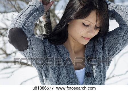 Stock Photo - Young female posing in front of snowy scene. Fotosearch