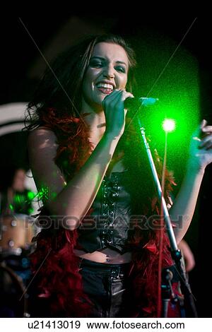 Stock Photo - Young female singing on stage in nightclub. Fotosearch