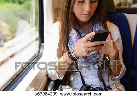 Stock Photo - Young female tourist on traveling on local train, Catalonia, Spain. Fotosearch