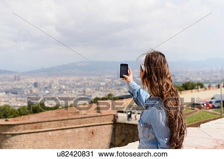 Young female tourist photographing view of Barcelona city, Spain View Large Photo Image Stock Image - Young female tourist photographing view of Barcelona city, Spain. Fotosearch