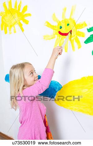Young girl painting smiling sunshine on wall View Large Photo Image Stock Photo - Young girl painting smiling sunshine on wall. Fotosearch