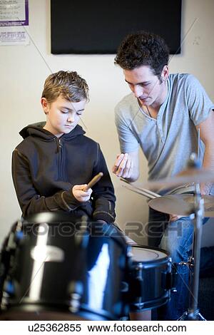 Young male teaching boy how to hold drumsticks View Large Photo Image Stock Photography - Young male teaching boy how to hold drumsticks. Fotosearch