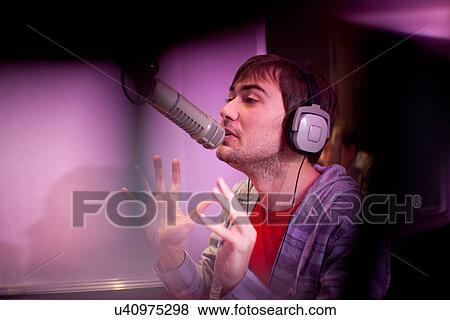 Stock Photo - Young man broadcasting in recording studio. Fotosearch