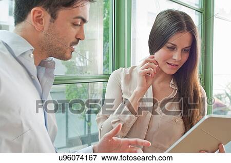 Young office workers looking at digital tablet View Large Photo Image Stock Photo - Young office workers looking at digital tablet. Fotosearch