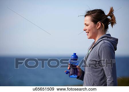 Young woman at coast taking exercise break View Large Photo Image Stock Photo - Young woman at coast taking exercise break. Fotosearch