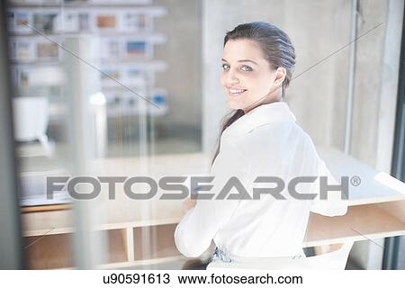 Young woman at desk in creative office View Large Photo Image Stock Image - Young woman at desk in creative office. Fotosearch