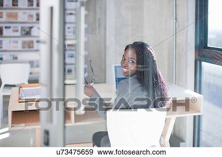 Young woman at desk in office View Large Photo Image Stock Photo - Young woman at desk in office. Fotosearch