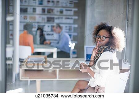 Picture - Young woman at desk. Fotosearch