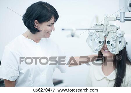 Young woman at opticians having eye test View Large Photo Image Stock Photo - Young woman at opticians having eye test. Fotosearch