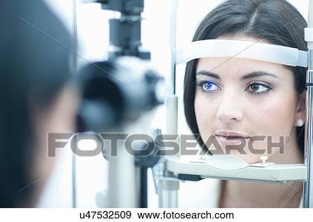 Stock Photo - Young woman having eye examination. Fotosearch