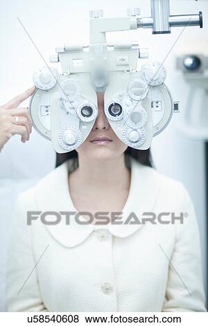 Stock Photo - Young woman having eye test at opticians. Fotosearch