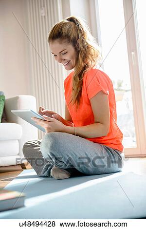 Young woman holding and using digital tablet at home View Large Photo Image Stock Photo - Young woman holding and using digital tablet at home. Fotosearch