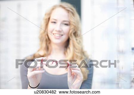 Young woman holding eyeglasses View Large Photo Image Stock Image - Young woman holding eyeglasses. Fotosearch