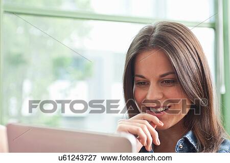 Young woman looking at digital tablet View Large Photo Image Stock Photo - Young woman looking at digital tablet. Fotosearch