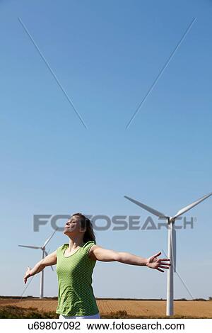 Young woman mimicking wind turbines View Large Photo Image Stock Image - Young woman mimicking wind turbines. Fotosearch