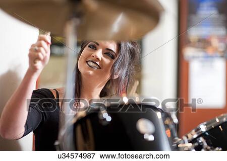 Young woman playing drum kit in music store View Large Photo Image Stock Photo - Young woman playing drum kit in music store. Fotosearch