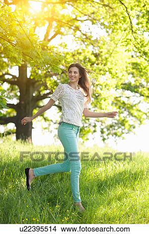 Young woman running through meadow View Large Photo Image Picture - Young woman running through meadow. Fotosearch
