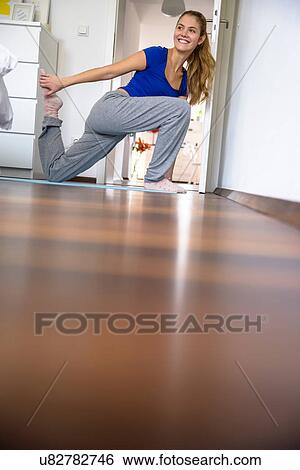 Young woman stretching and exercising at home View Large Photo Image Stock Photograph - Young woman stretching and exercising at home. Fotosearch