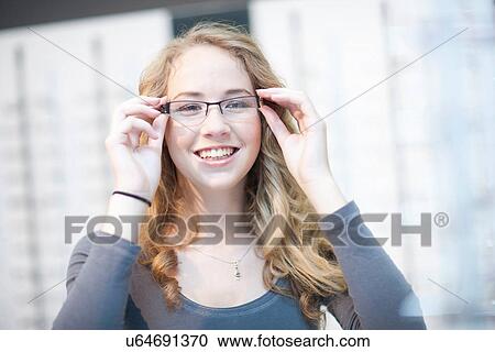 Young woman trying on eyeglasses View Large Photo Image Stock Image - Young woman trying on eyeglasses. Fotosearch
