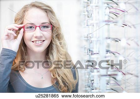 Young woman trying on eyeglasses View Large Photo Image Stock Photography - Young woman trying on eyeglasses. Fotosearch