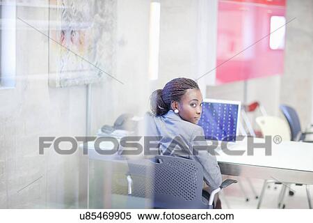 Stock Photography - Young woman using computer in office. Fotosearch