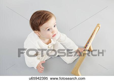 Baby boy looking at abacus View Large Photo Image Stock Photography - Baby boy looking at abacus. Fotosearch