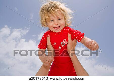 Baby girl held in midair View Large Photo Image Stock Image - Baby girl held in midair. Fotosearch