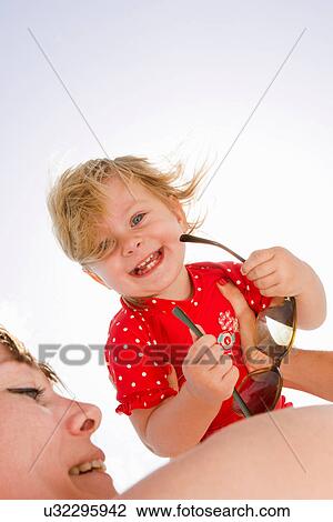 Stock Image - Baby looking over mother's shoulder. Fotosearch