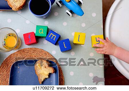 Stock Image - Baby spelling with alphabet blocks. Fotosearch