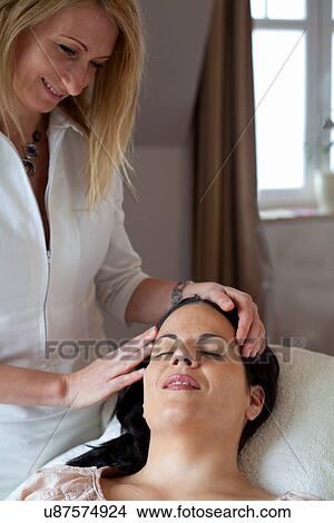 Picture - Beautician performing beauty treatment on woman. Fotosearch