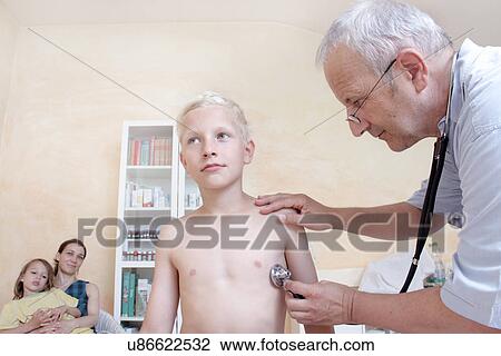 Stock Image - Boy being examining by doctor with stethoscope. Fotosearch