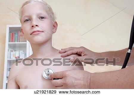 Stock Photo - Boy being examining by doctor with stethoscope. Fotosearch