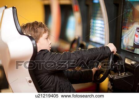 Stock Photography - Boy playing on driving video game. Fotosearch