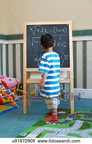 Boy standing beside blackboard with algebra View Large Photo Image Stock Photo - Boy standing beside blackboard with algebra. Fotosearch