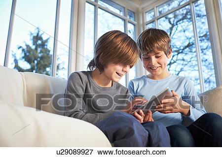 Brothers using digital tablet together View Large Photo Image Stock Photo - Brothers using digital tablet together. Fotosearch