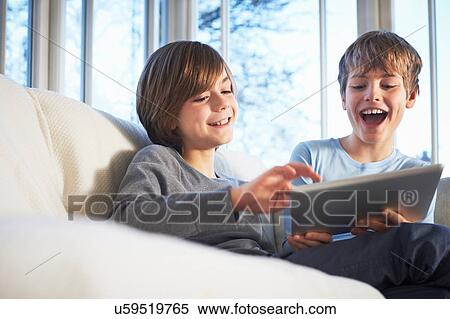 Stock Photography - Brothers using digital tablet together. Fotosearch