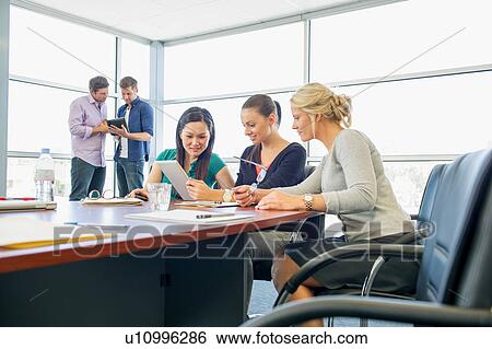 Stock Photograph - Business executives at brainstorming meeting. Fotosearch