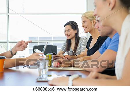Stock Photograph - Business executives at brainstorming meeting. Fotosearch