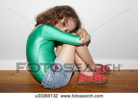 Stock Image - Child on floor in fetal position. Fotosearch